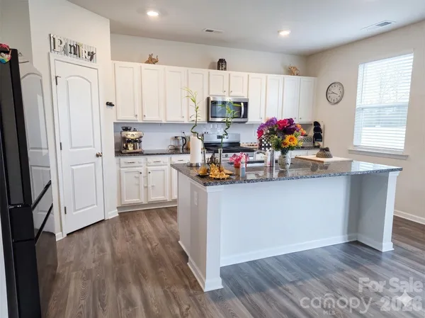 a kitchen with granite countertop a refrigerator stove top oven and sink