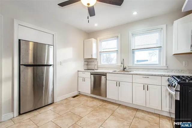 a kitchen with white cabinets and white appliances