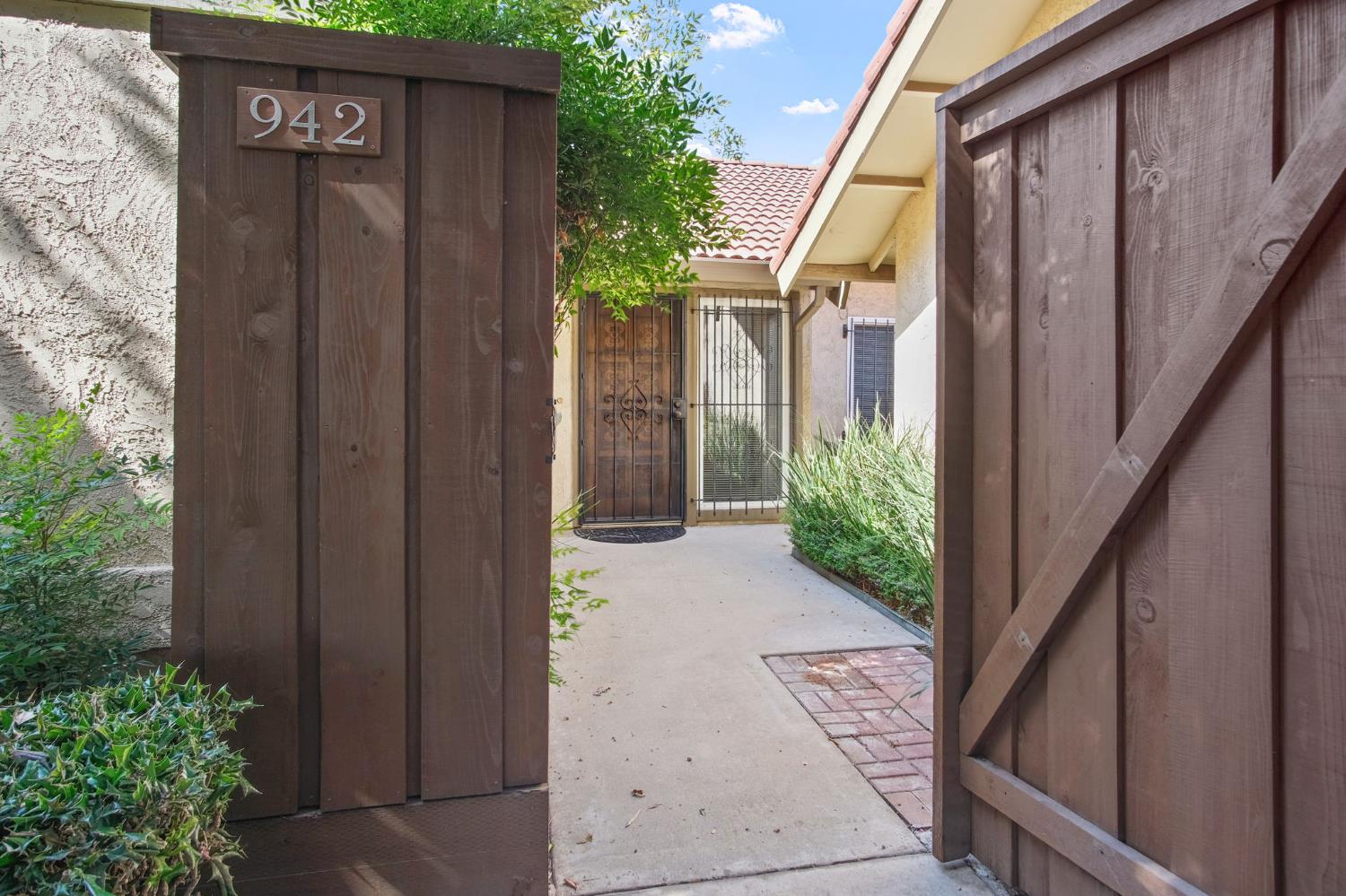 a view of a house with wooden fence next to a yard