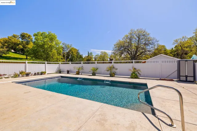 swimming pool view with a seating space and a garden view