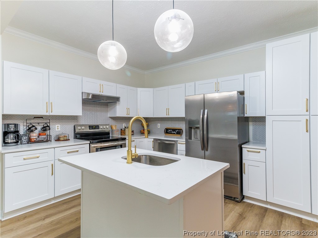 6915 South Staff Road Fayetteville, NC 28306 - Photo 11 of 23 a kitchen with refrigerator cabinets and wooden floor