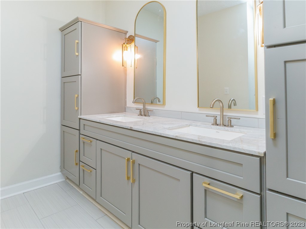 6915 South Staff Road Fayetteville, NC 28306 - Photo 15 of 23 a bathroom with a double vanity sink and a mirror