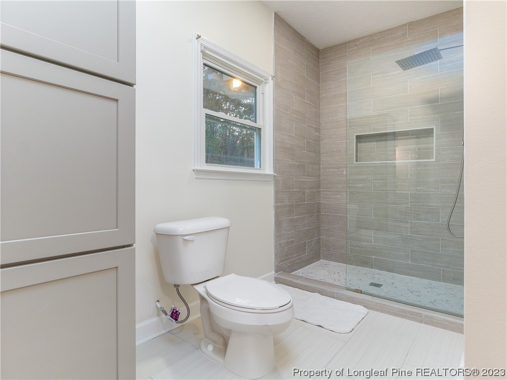 6915 South Staff Road Fayetteville, NC 28306 - Photo 16 of 23 a bathroom with a toilet and a shower