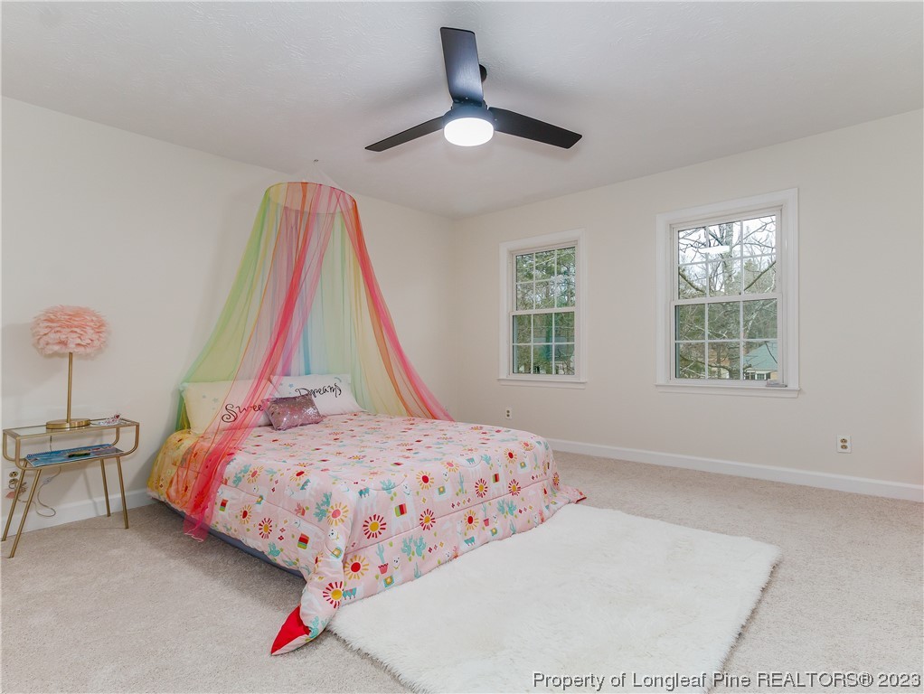 6915 South Staff Road Fayetteville, NC 28306 - Photo 18 of 23 a bedroom with a bed and a chandelier