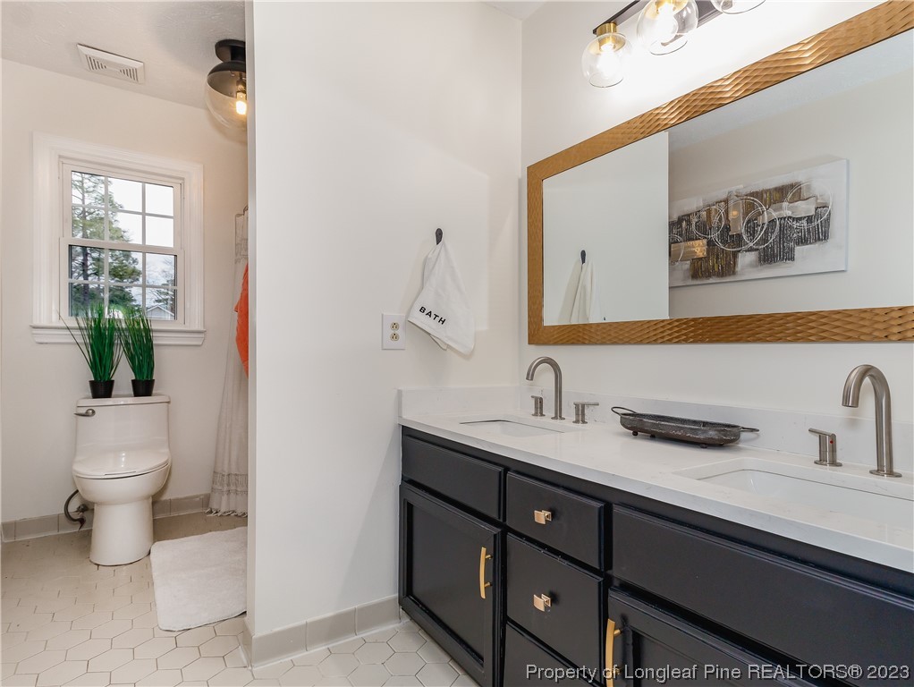 6915 South Staff Road Fayetteville, NC 28306 - Photo 20 of 23 a bathroom with a toilet sink and mirror