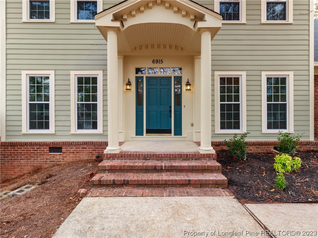 6915 South Staff Road Fayetteville, NC 28306 - Photo 3 of 23 a front view of a house with entryway and windows