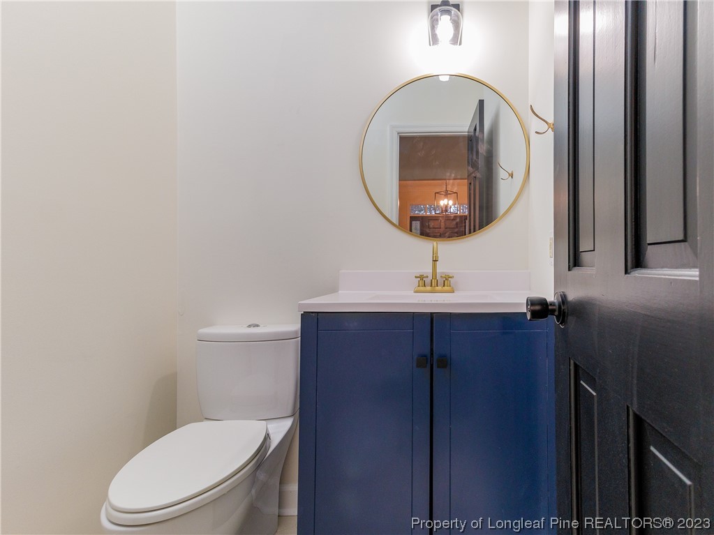 6915 South Staff Road Fayetteville, NC 28306 - Photo 6 of 23 a bathroom with a toilet a sink and a mirror