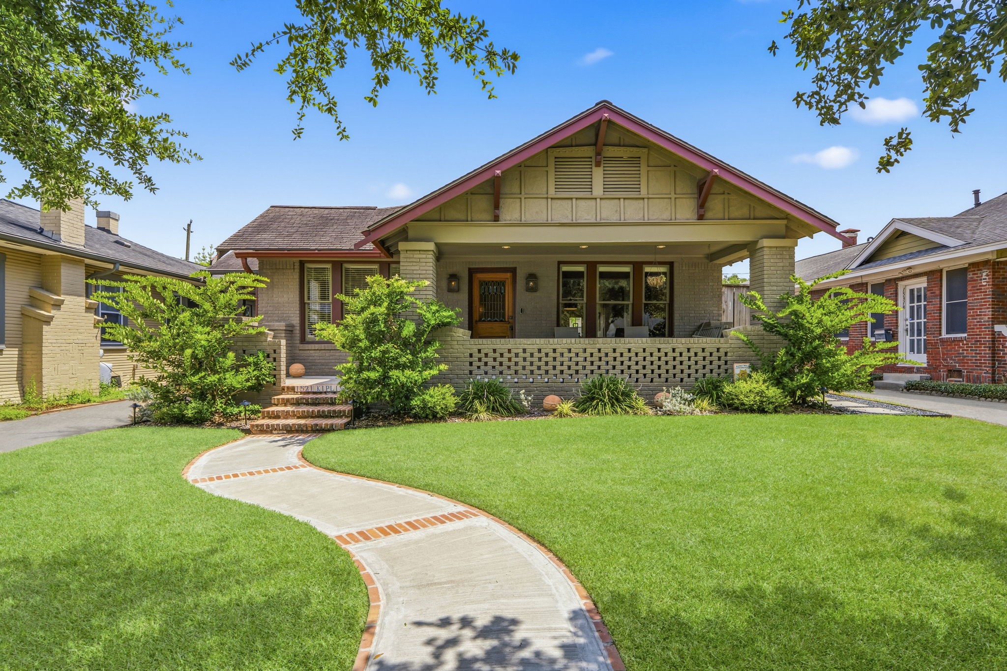 Charming Craftsman-style home with a welcoming front porch, manicured lawn, and a curved walkway. Ideal for those seeking a cozy and picturesque neighborhood setting.