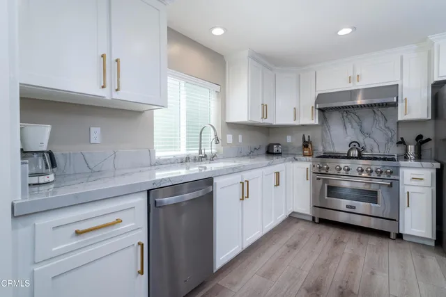 a kitchen with white cabinets and white appliances