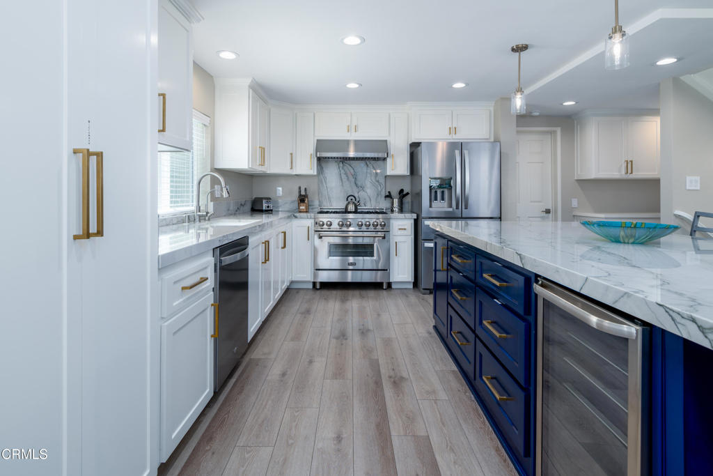 117 Santa Cruz Avenue Oxnard, CA 93035 - Photo 12 of 35 a kitchen with stainless steel appliances granite countertop refrigerator a sink and wooden cabinets
