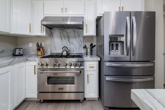 a kitchen with stainless steel appliances and white cabinets