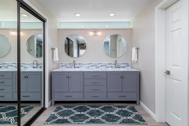 a bathroom with double vanity and a mirror