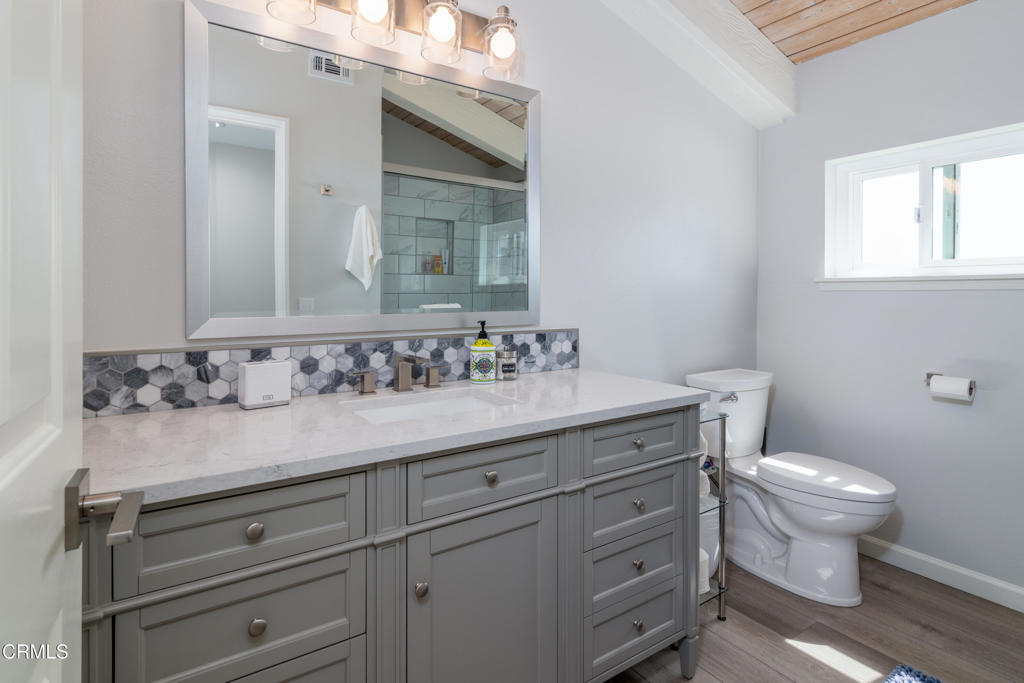 117 Santa Cruz Avenue Oxnard, CA 93035 - Photo 25 of 35 a bathroom with a granite countertop toilet sink and mirror