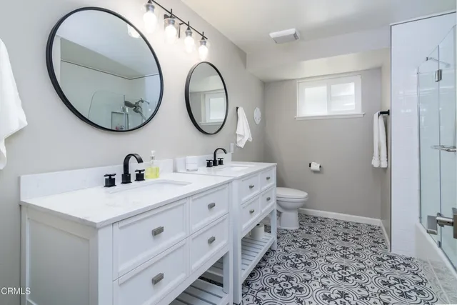 a bathroom with a double vanity sink mirror and a toilet
