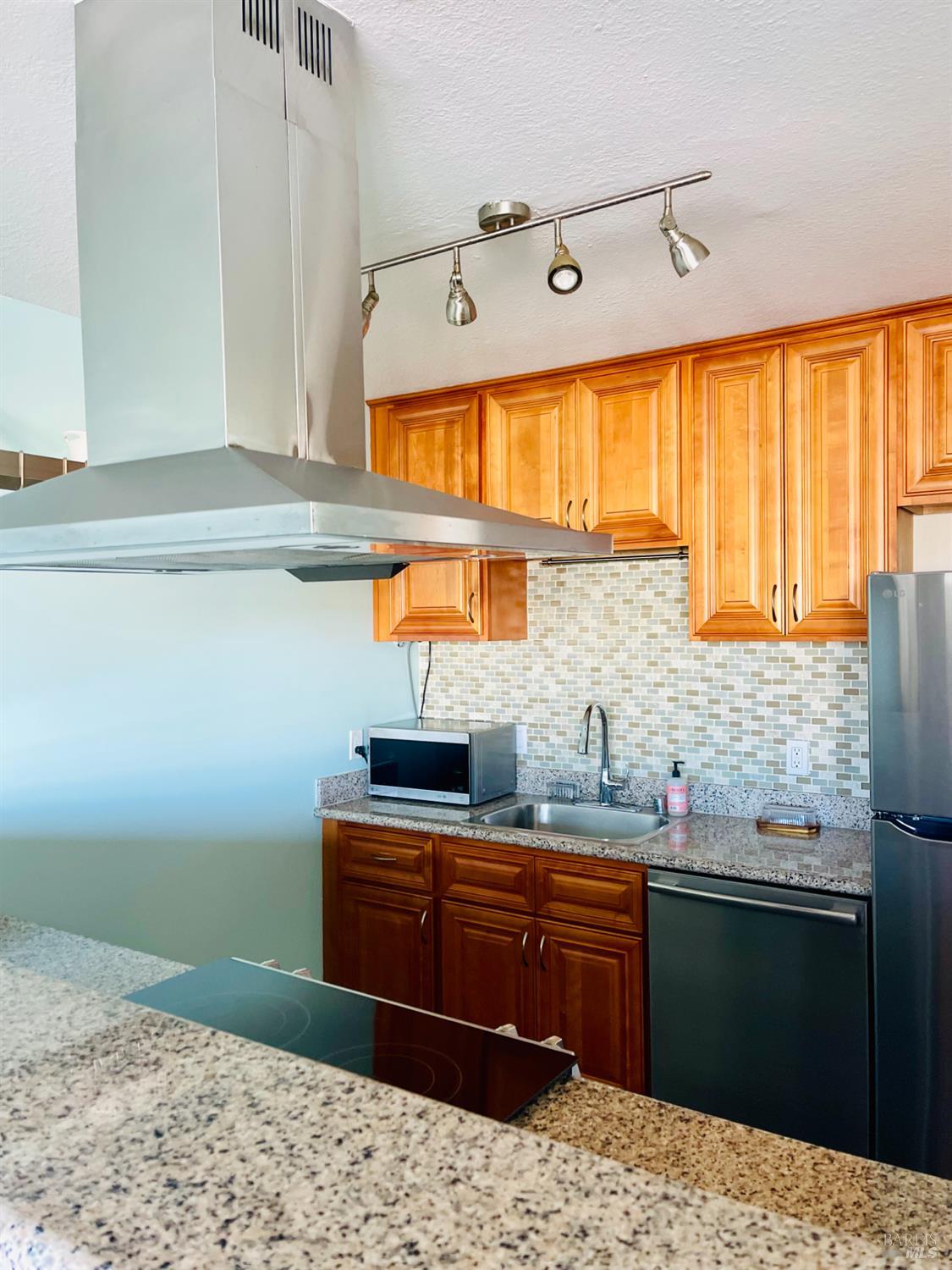 1 Embarcadero West, Unit 355 Oakland, CA 94607 - Photo 6 of 20 a kitchen with stainless steel appliances kitchen island granite countertop a sink and cabinets
