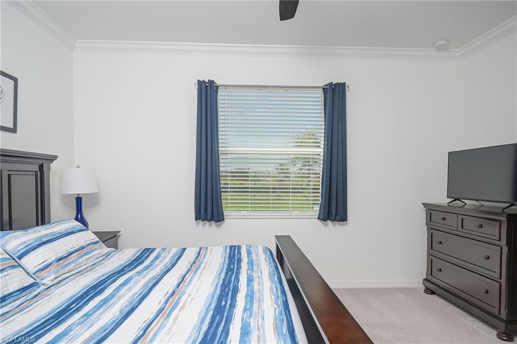 1774 Alameda Drive Naples, FL 34120 - Photo 12 of 29 a bedroom with a bed and a flat tv screen on a dresser