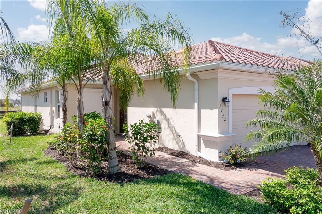 1774 Alameda Drive Naples, FL 34120 - Photo 3 of 29 a front view of a house with garden