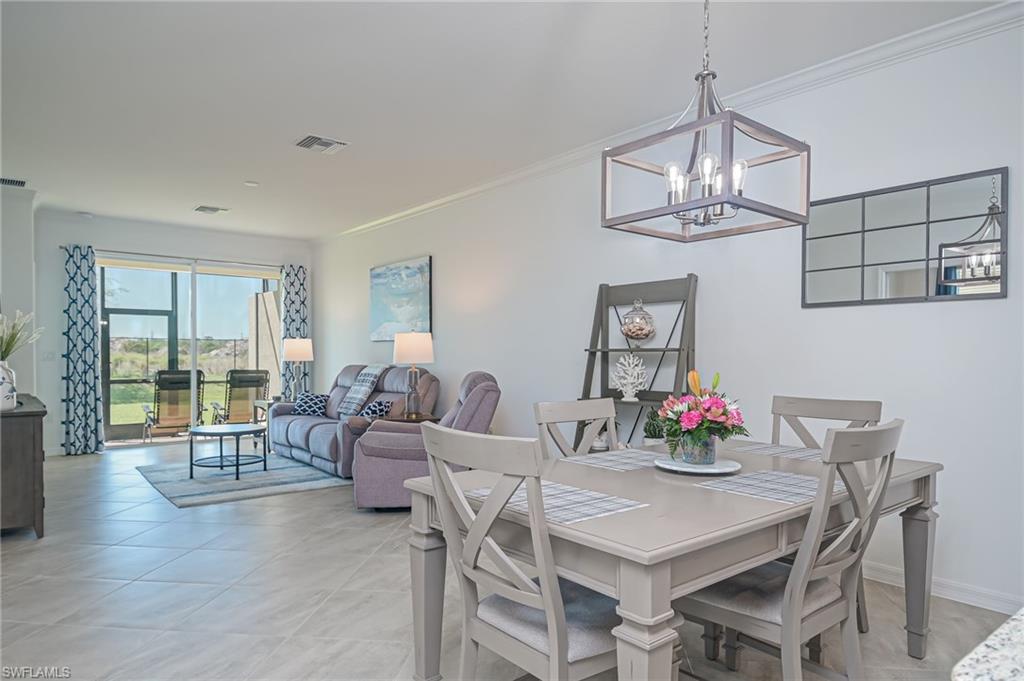 1774 Alameda Drive Naples, FL 34120 - Photo 4 of 29 a view of a dining room with furniture a chandelier and wooden floor