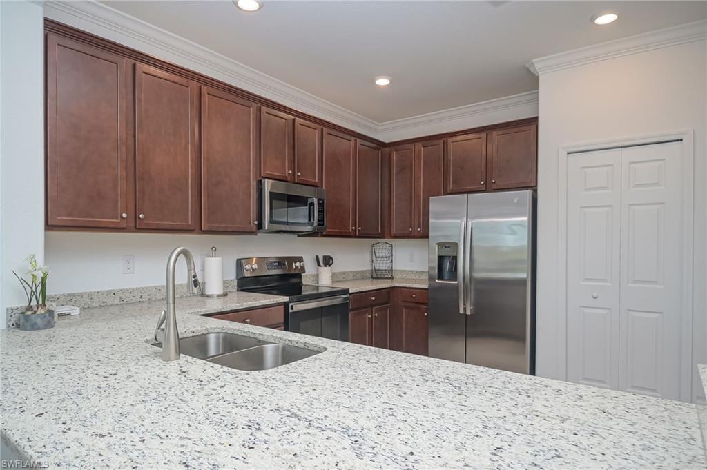 1774 Alameda Drive Naples, FL 34120 - Photo 8 of 29 a kitchen with stainless steel appliances granite countertop a refrigerator a stove a sink and a white cabinets