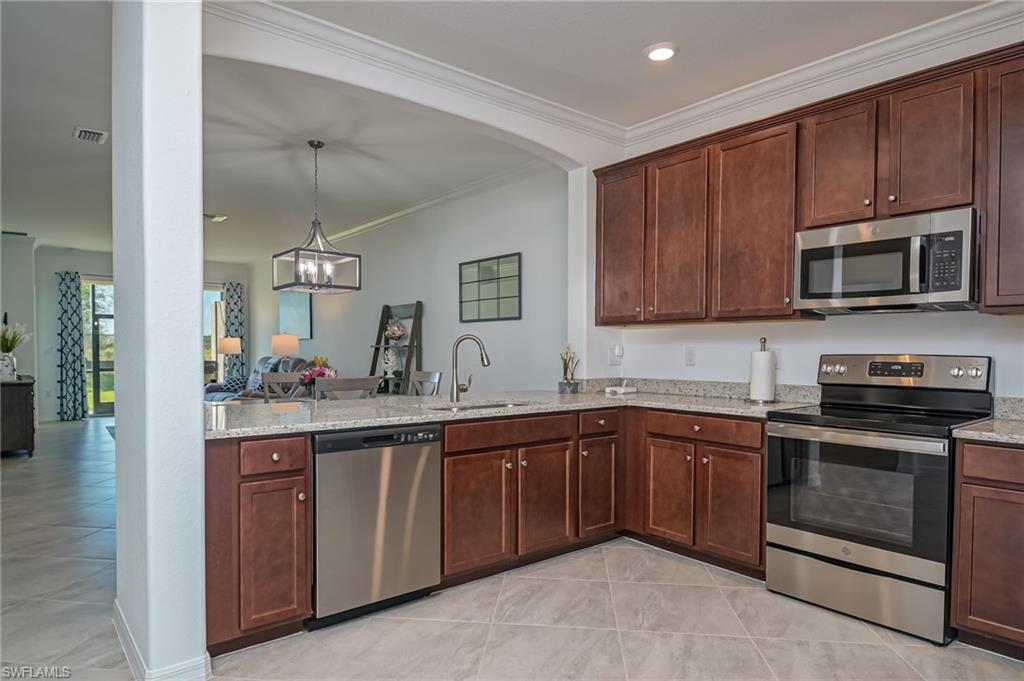 1774 Alameda Drive Naples, FL 34120 - Photo 10 of 29 a kitchen with sink cabinets and stainless steel appliances