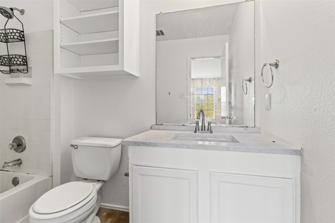 12700 St Mary Drive Manor, TX 78653 - Photo 11 of 17 a bathroom with a granite countertop toilet sink and mirror