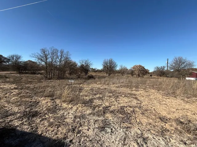 a view of a field with trees in background