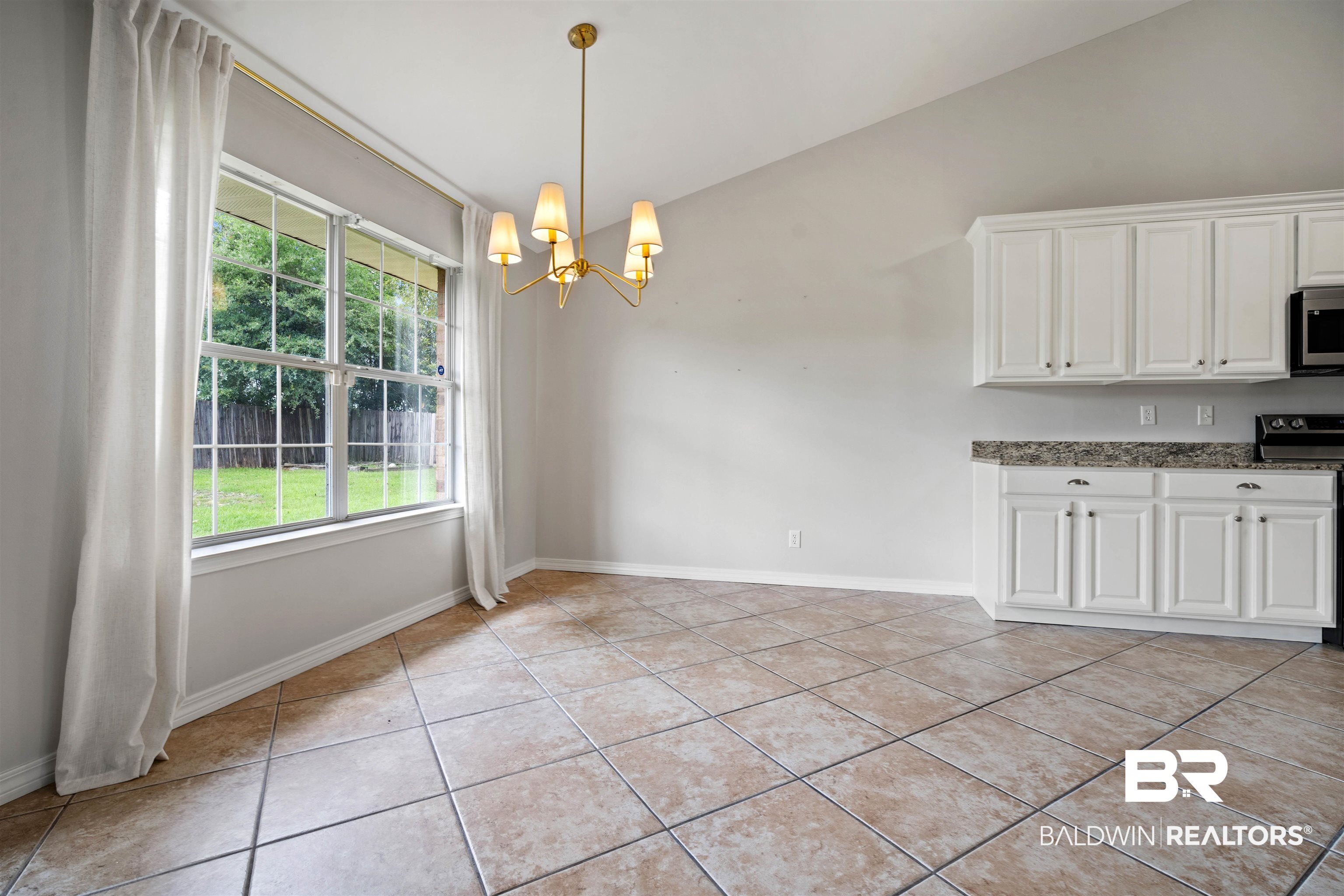 4000 Fenwick Loop Mobile, AL 36619 - Photo 9 of 31 Unfurnished dining area with a chandelier, light tile patterned floors, healthy amount of natural light, and vaulted ceiling