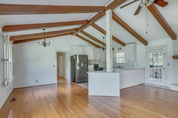 a kitchen with stainless steel appliances kitchen island wooden floors and refrigerator