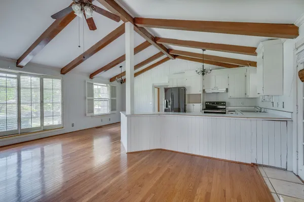 a view of a kitchen with wooden floor and a sink