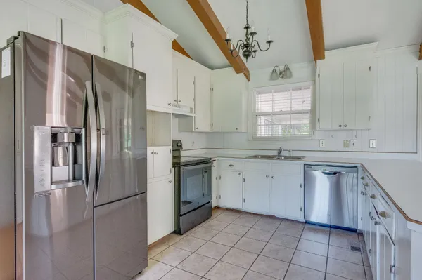 a kitchen with a refrigerator sink and cabinets