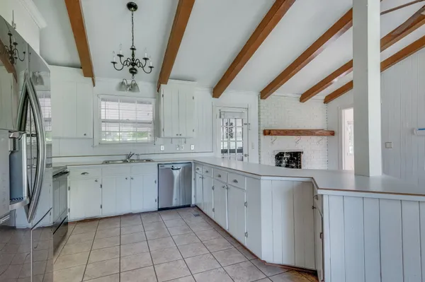 a kitchen with granite countertop cabinets a sink a window and stainless steel appliances