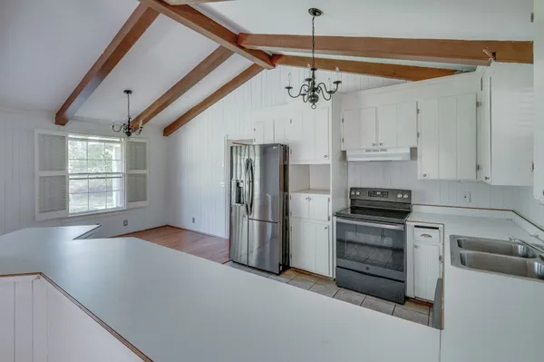 a view of a kitchen with a stove cabinets and stainless steel appliances