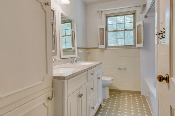 a bathroom with a sink a toilet and a window