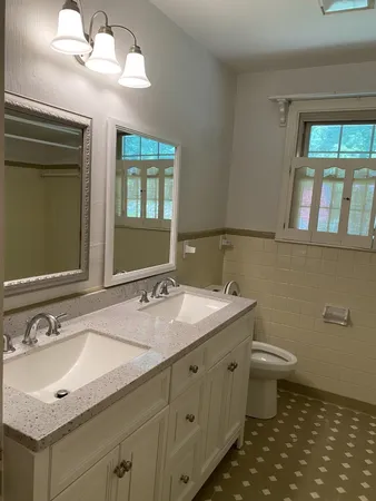 a bathroom with a granite countertop sink a toilet and a mirror