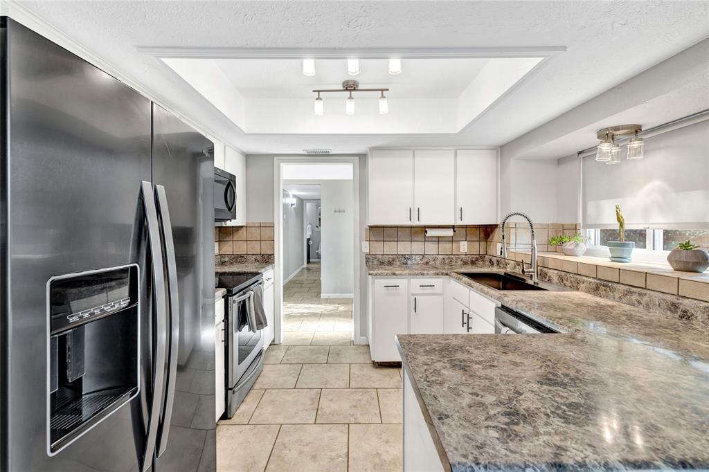 2609 Quail Ridge Irving, TX 75060 - Photo 11 of 39 a kitchen with granite countertop a refrigerator and a sink