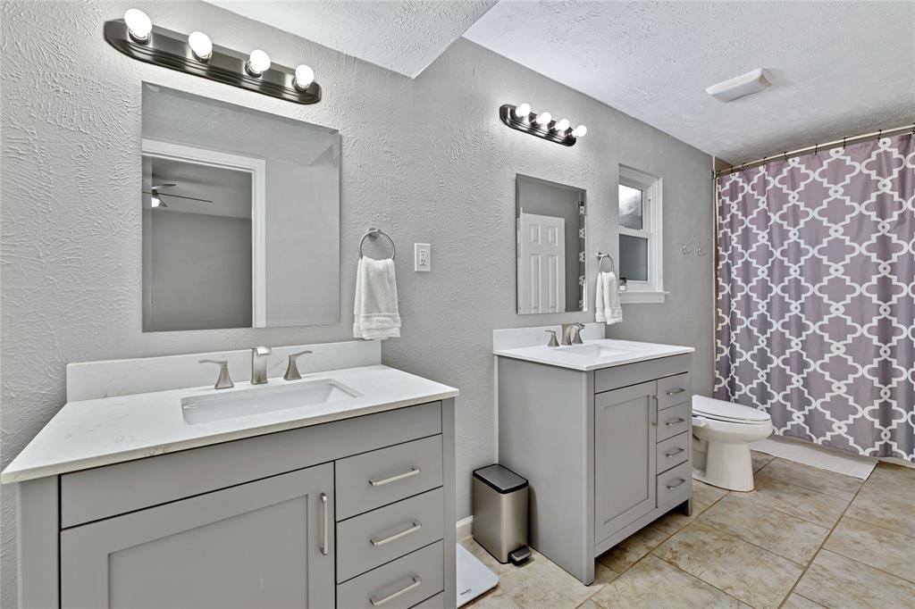 2609 Quail Ridge Irving, TX 75060 - Photo 16 of 39 a bathroom with a double vanity sink mirror and toilet