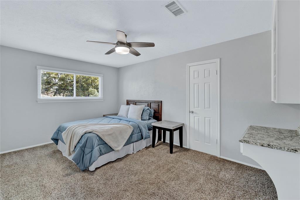 2609 Quail Ridge Irving, TX 75060 - Photo 20 of 39 a spacious bedroom with a bed and a cabinets