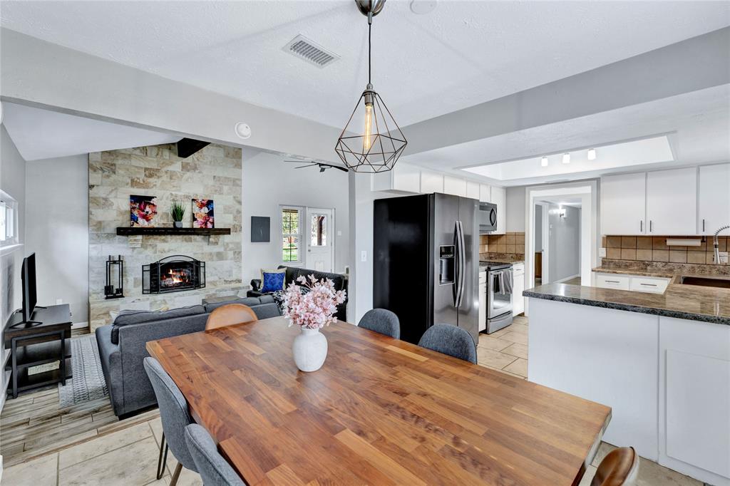 2609 Quail Ridge Irving, TX 75060 - Photo 10 of 39 a kitchen with stainless steel appliances granite countertop a dining table and chairs a refrigerator with wooden floor