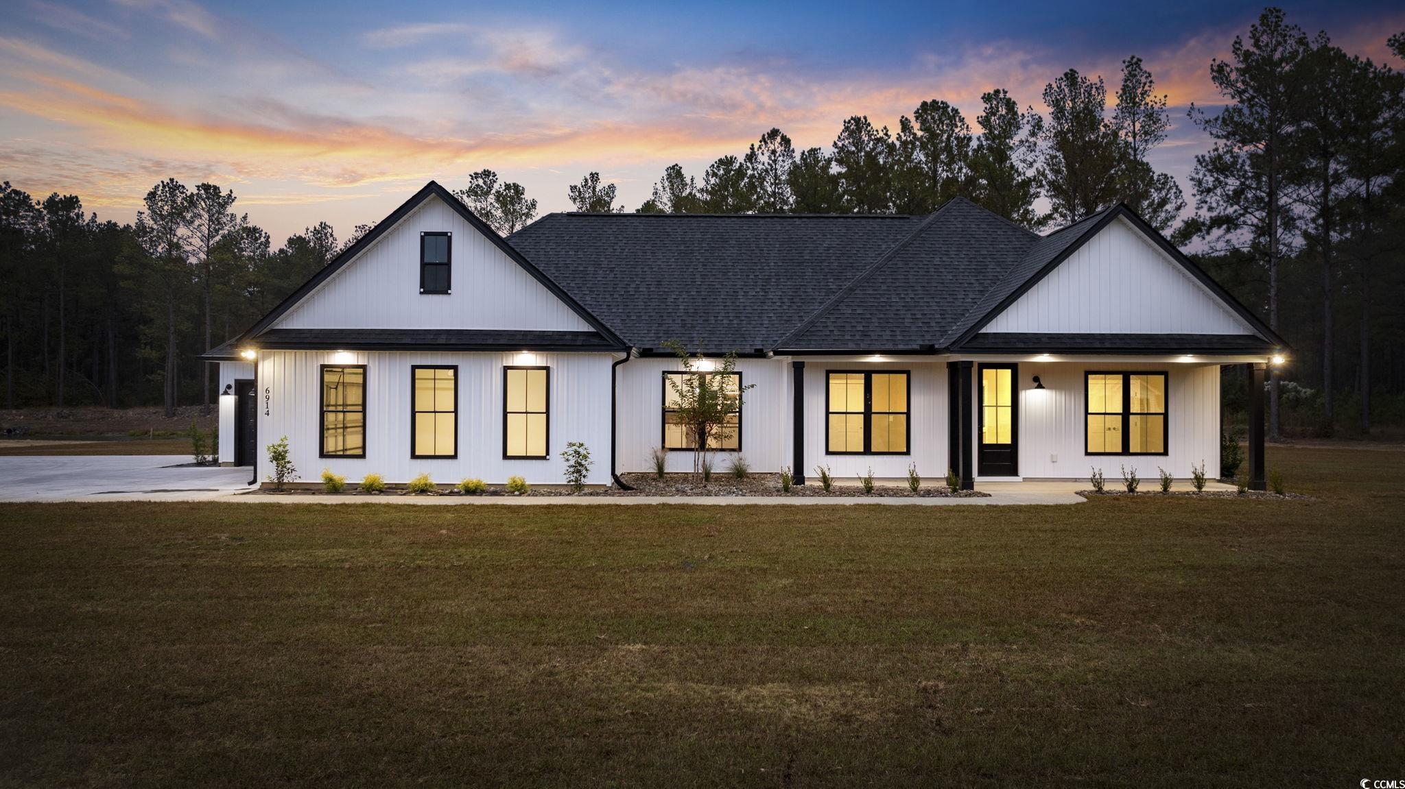Modern inspired farmhouse with a porch and a yard