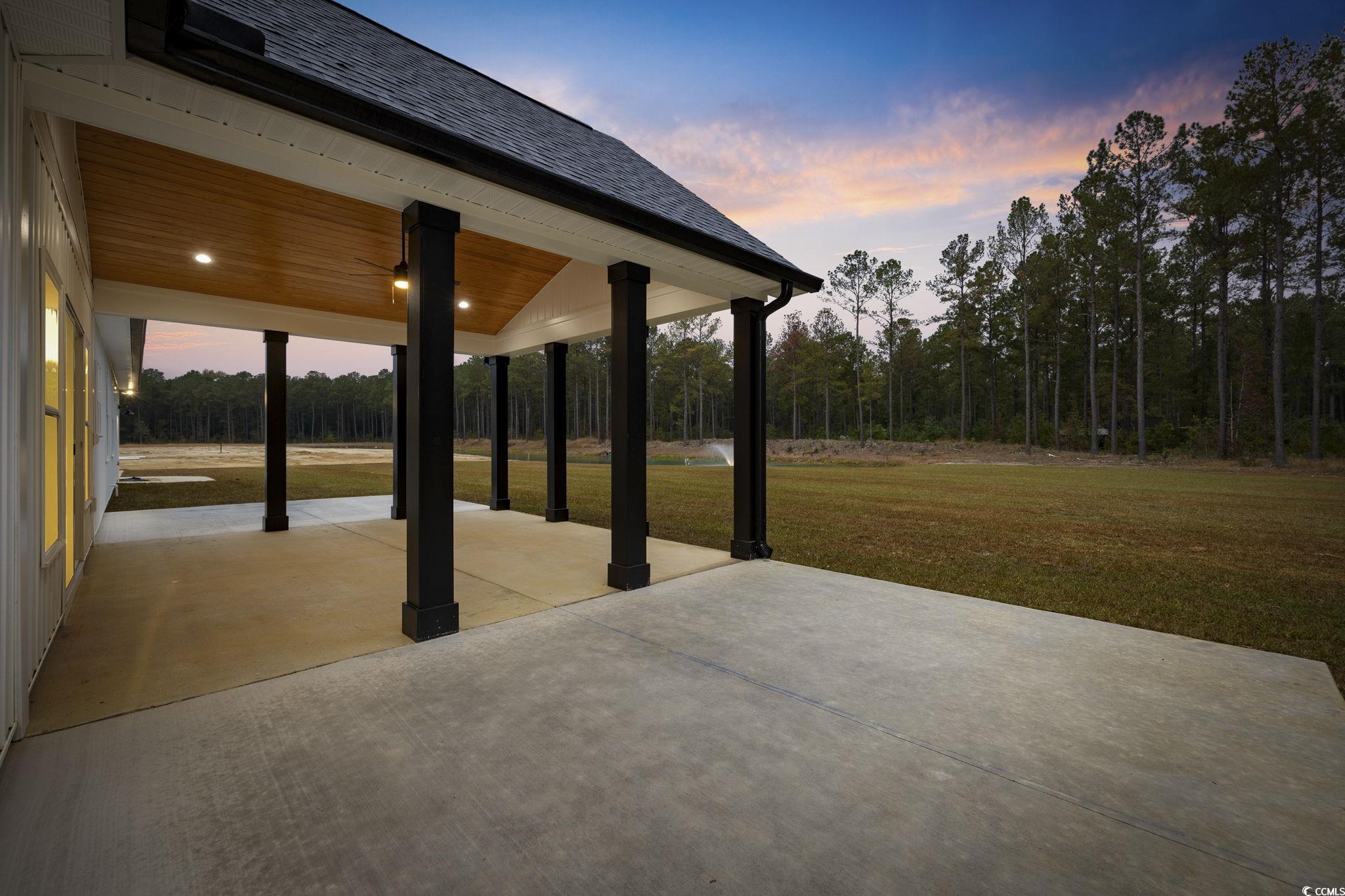 6914 Pauley Swamp Road Conway, SC 29527 - Photo 33 of 40 Patio terrace at dusk with a lawn