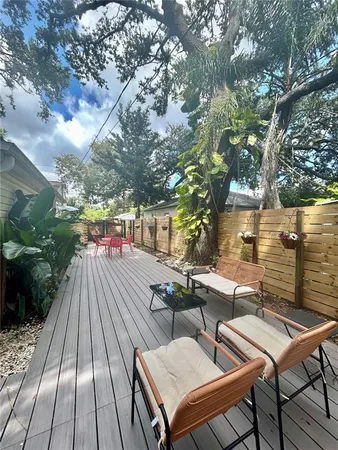 a roof deck with table and chairs a barbeque with wooden floor and fence