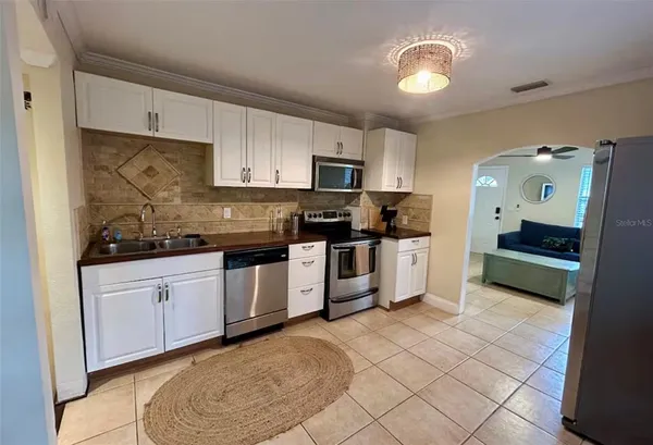 a kitchen with stainless steel appliances granite countertop a stove a sink and a refrigerator