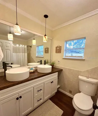 a bathroom with a granite countertop sink mirror vanity and toilet