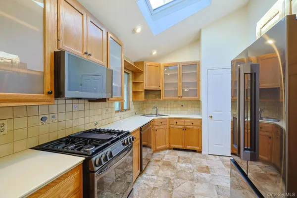 a kitchen with stainless steel appliances granite countertop a stove a sink and a refrigerator