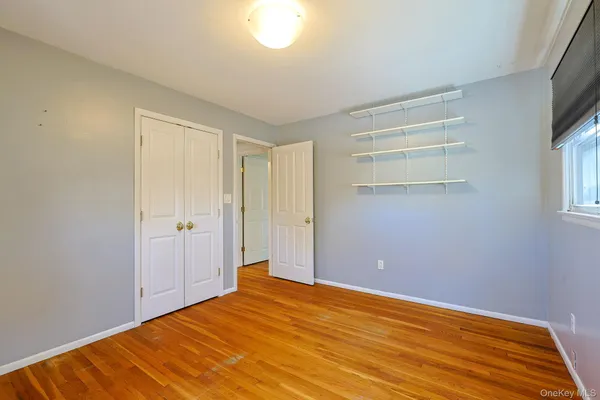 a view of empty room with window and wooden floor
