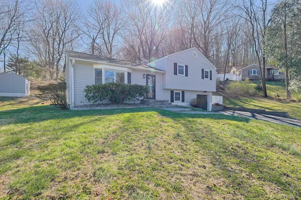 a front view of a house with a yard and trees