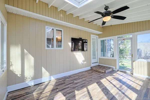 a view of a livingroom with wooden floor and a ceiling fan