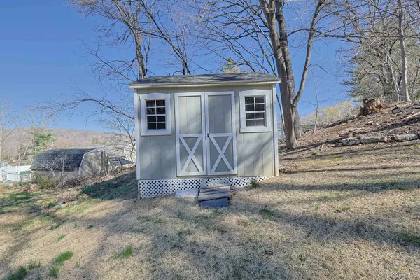 a view of a house with a large tree and wooden fence