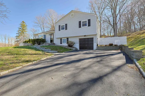 a view of a house with a yard and pathway