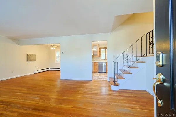 a view of an empty room with wooden floor and a floor to ceiling window